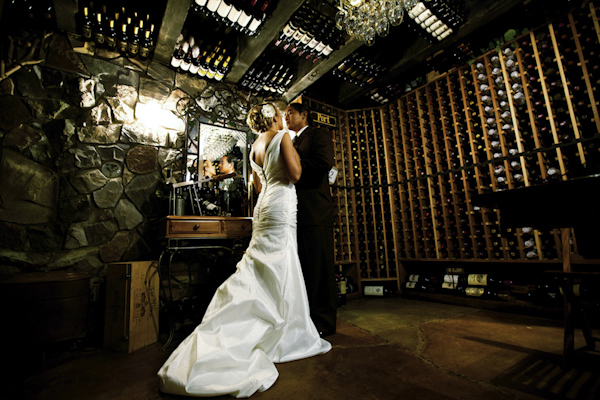 the newlywed standing in wine cellar - wedding photo by top Orange County, California wedding photographers D. Park Photography